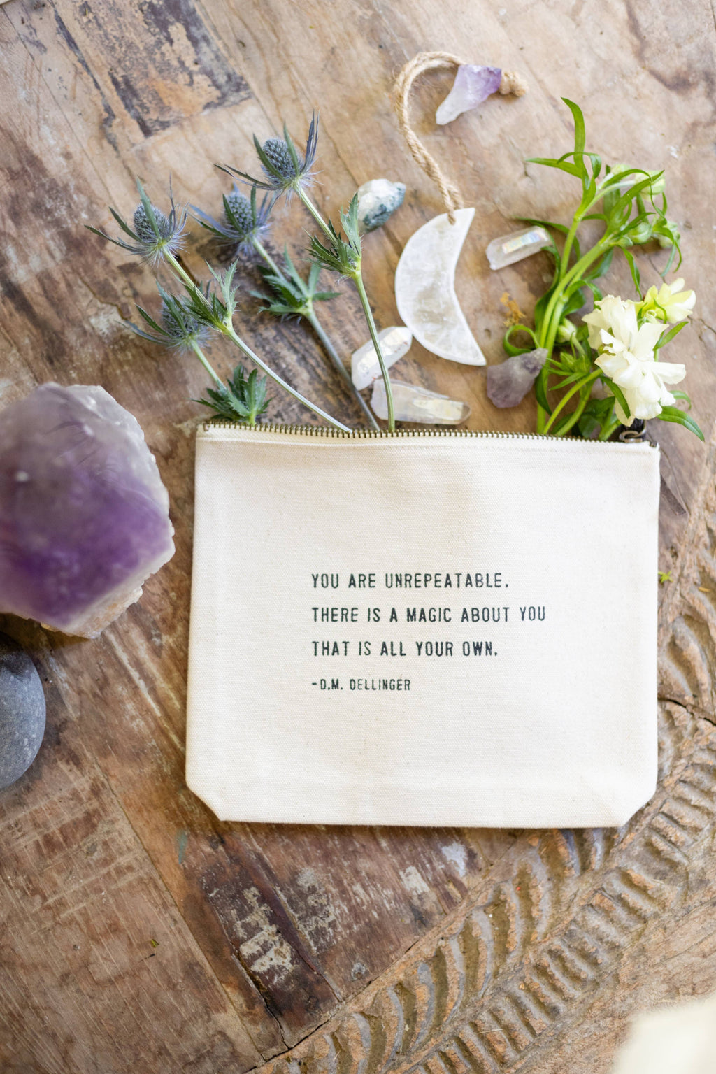 Small pouch with flowers and a quote on a wooden surface