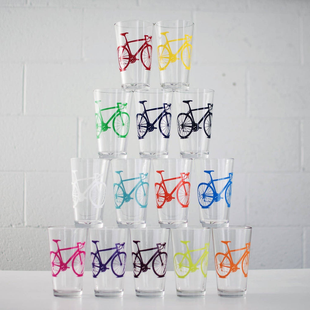 Set of clear glasses with colorful bicycle designs stacked on a white surface.