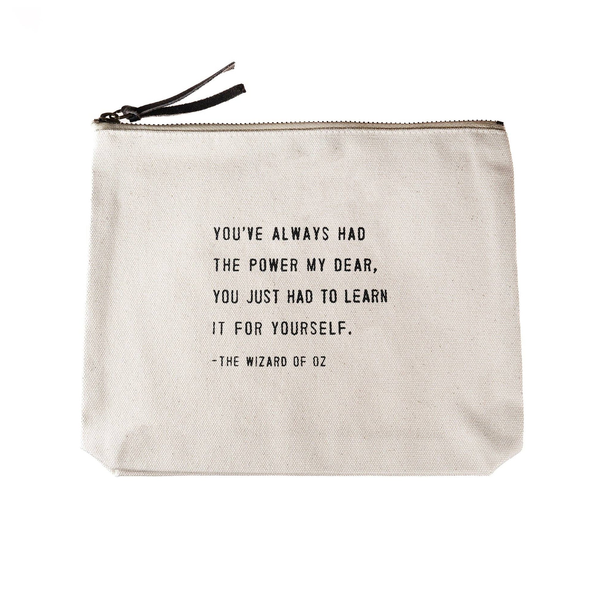 Beige pouch with black text quote from 'The Wizard of Oz' on a white background