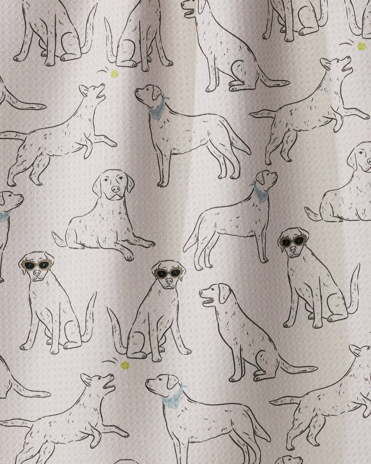A close-up of a fabric surface featuring an all-over print of illustrated dogs in black line drawings, with a few small blue and yellow accents, on a light warm beige background.