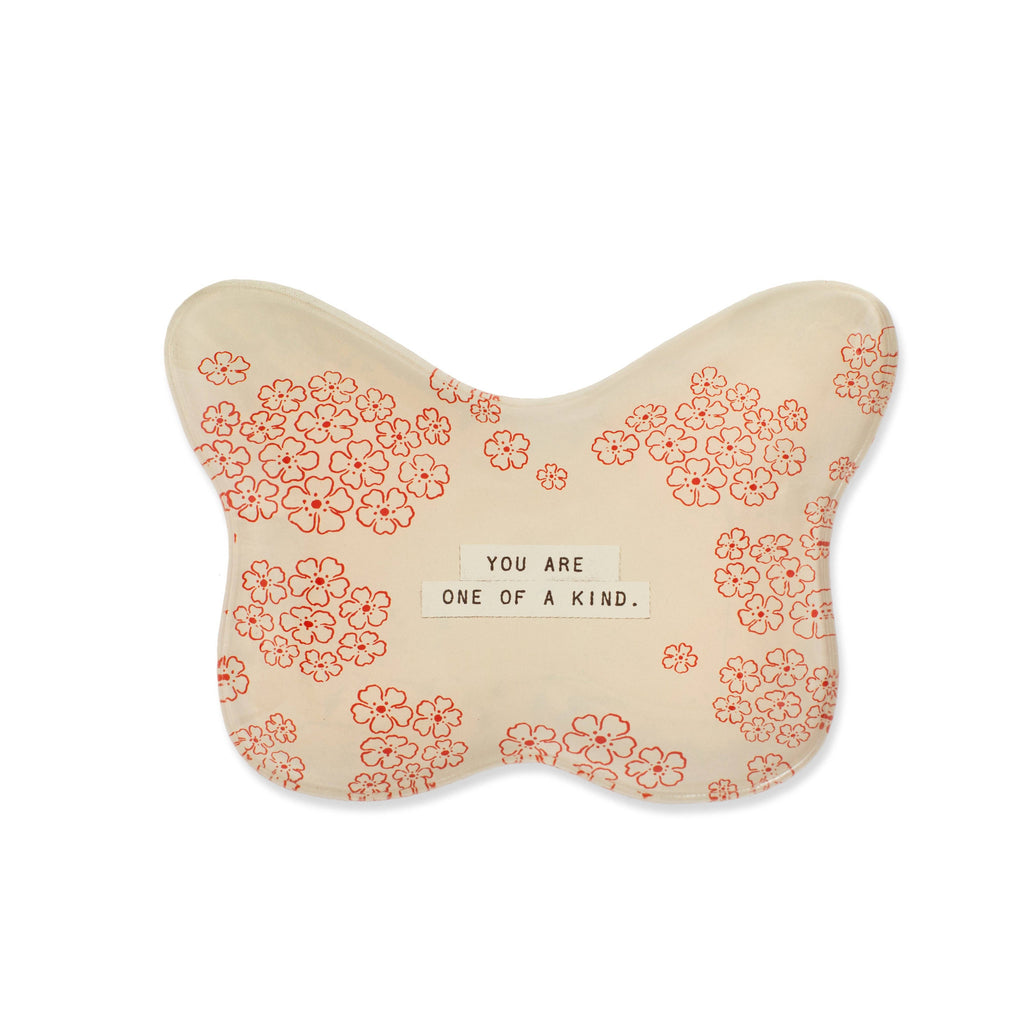 Butterfly-shaped pillow with floral pattern and motivational quote on a white background
