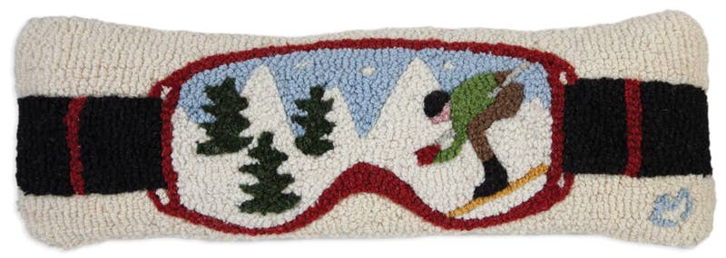 Decorative pillow with ski goggles design featuring a skier and trees.