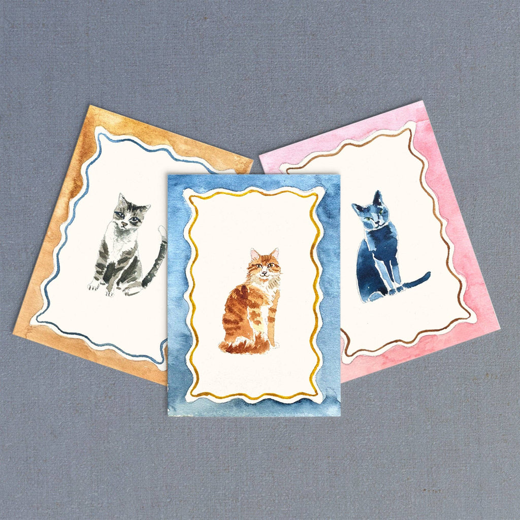 Three greeting cards with cat illustrations on a gray background