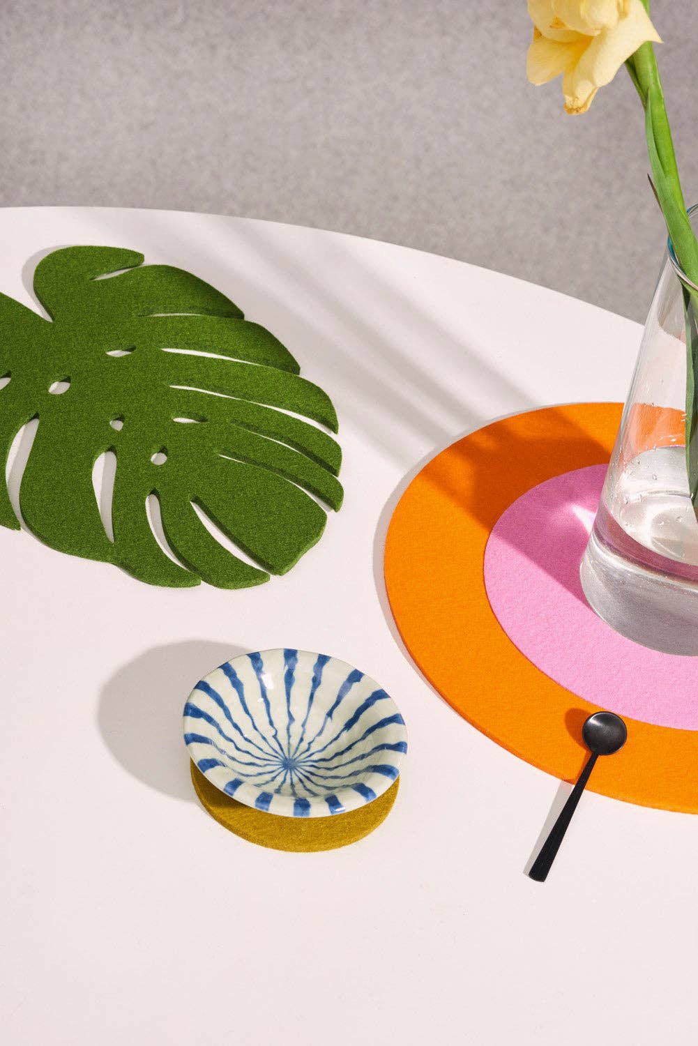 Colorful coasters with a leaf design on a white surface