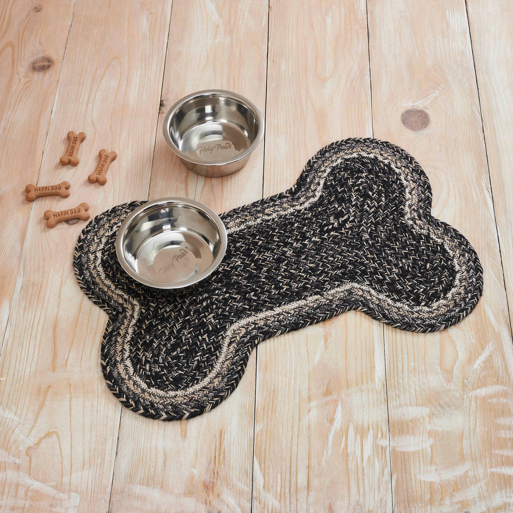 Dog bone-shaped mat with two metal bowls on a wooden floor.