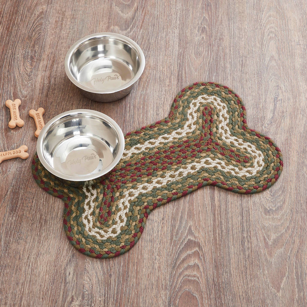 Two metal dog bowls on a braided mat shaped like a bone, with wooden floor in the background.