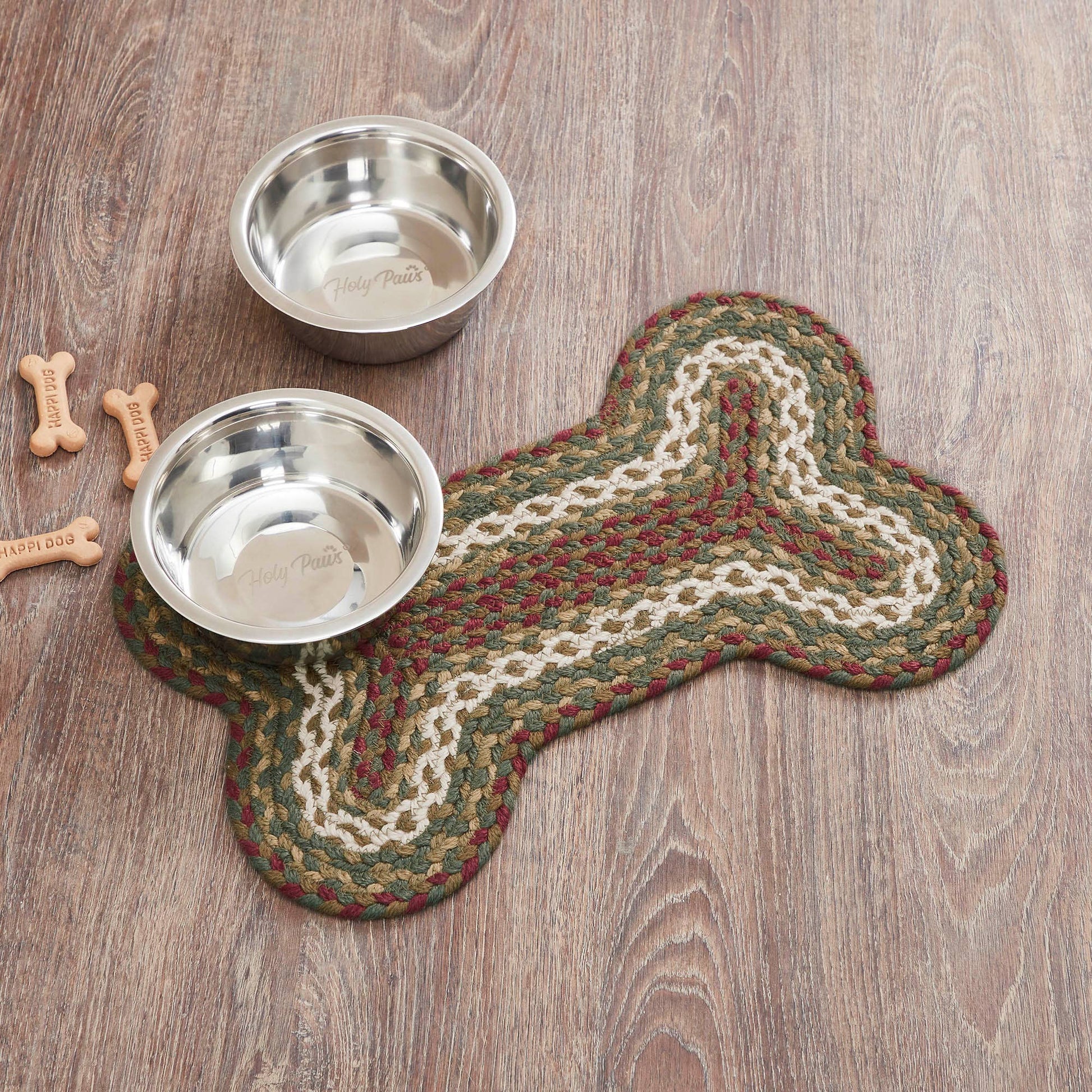 Two metal dog bowls on a braided mat shaped like a bone, with wooden floor in the background.