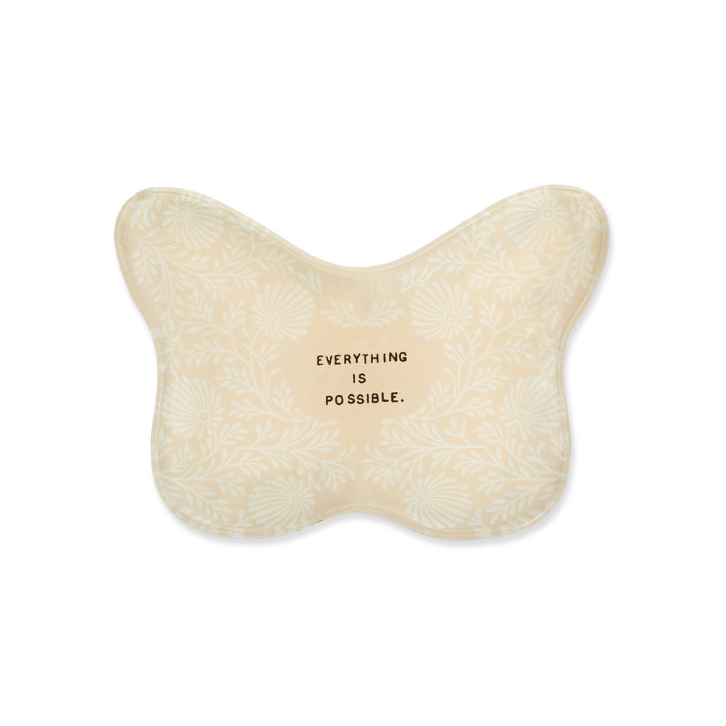 Butterfly-shaped pillow with 'Everything is possible' text on a white background