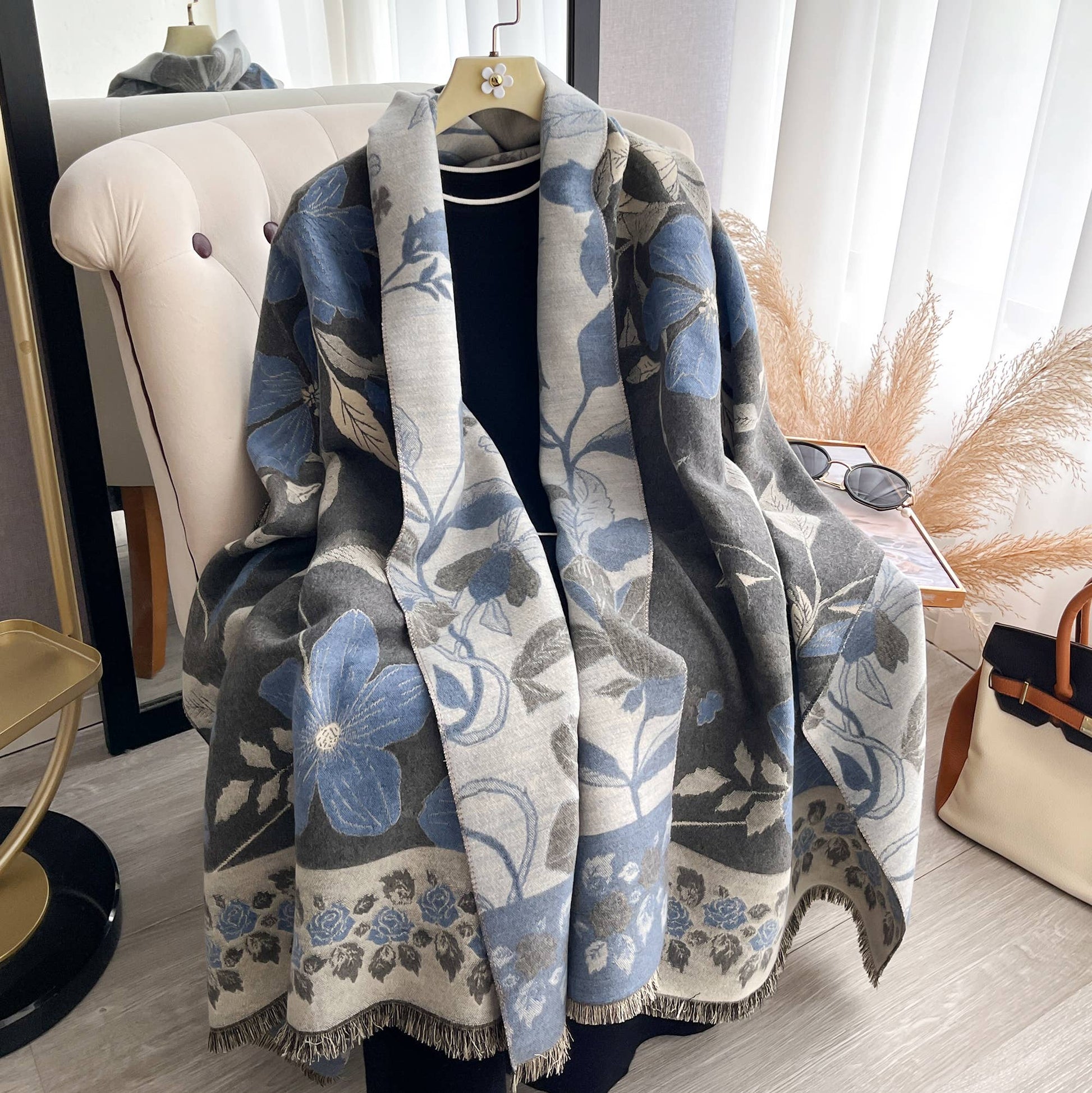 Floral patterned throw blanket draped over a chair in a room with decor elements.