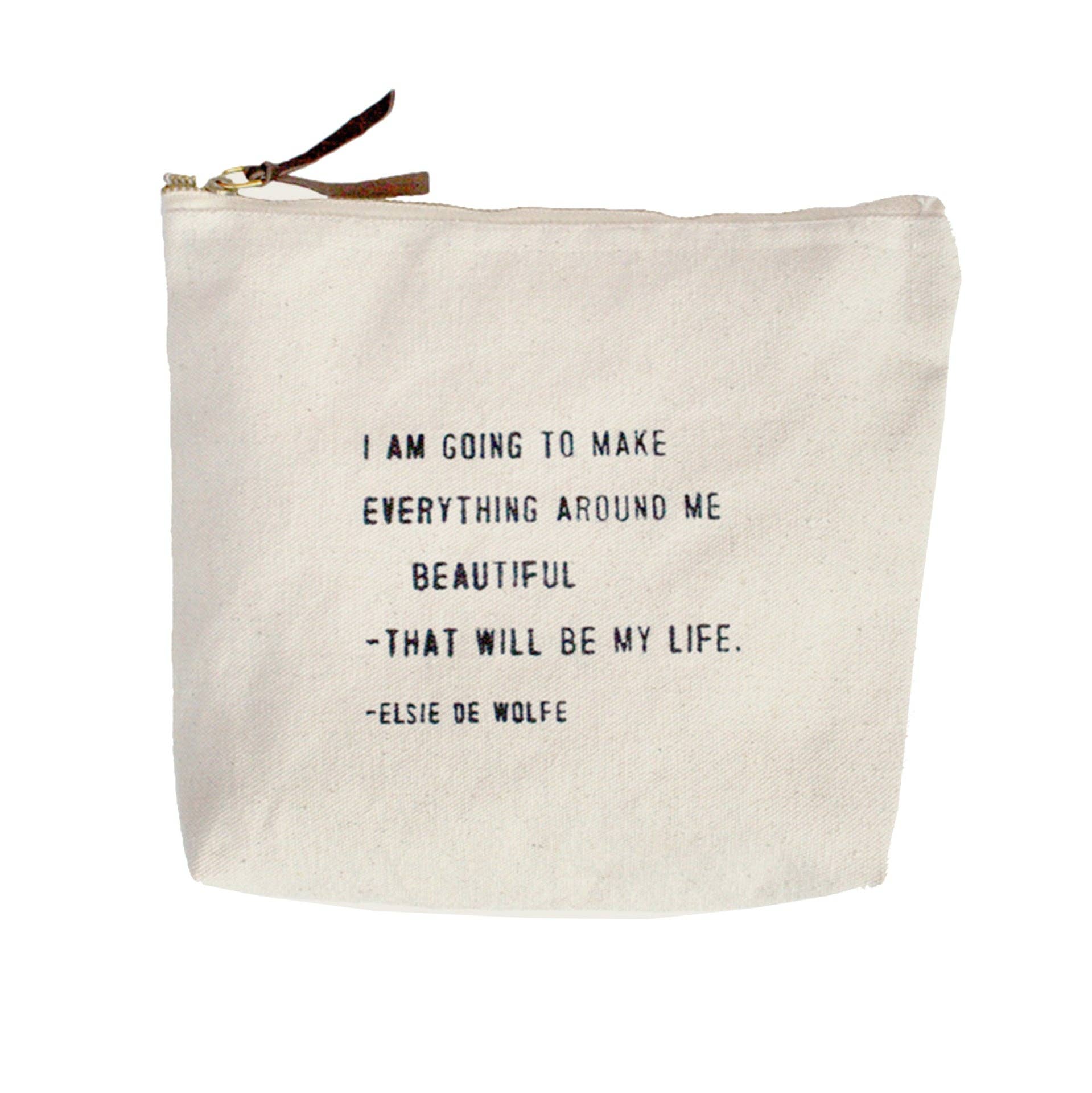 Beige pouch with motivational quote by Elsie de Wolfe on a white background