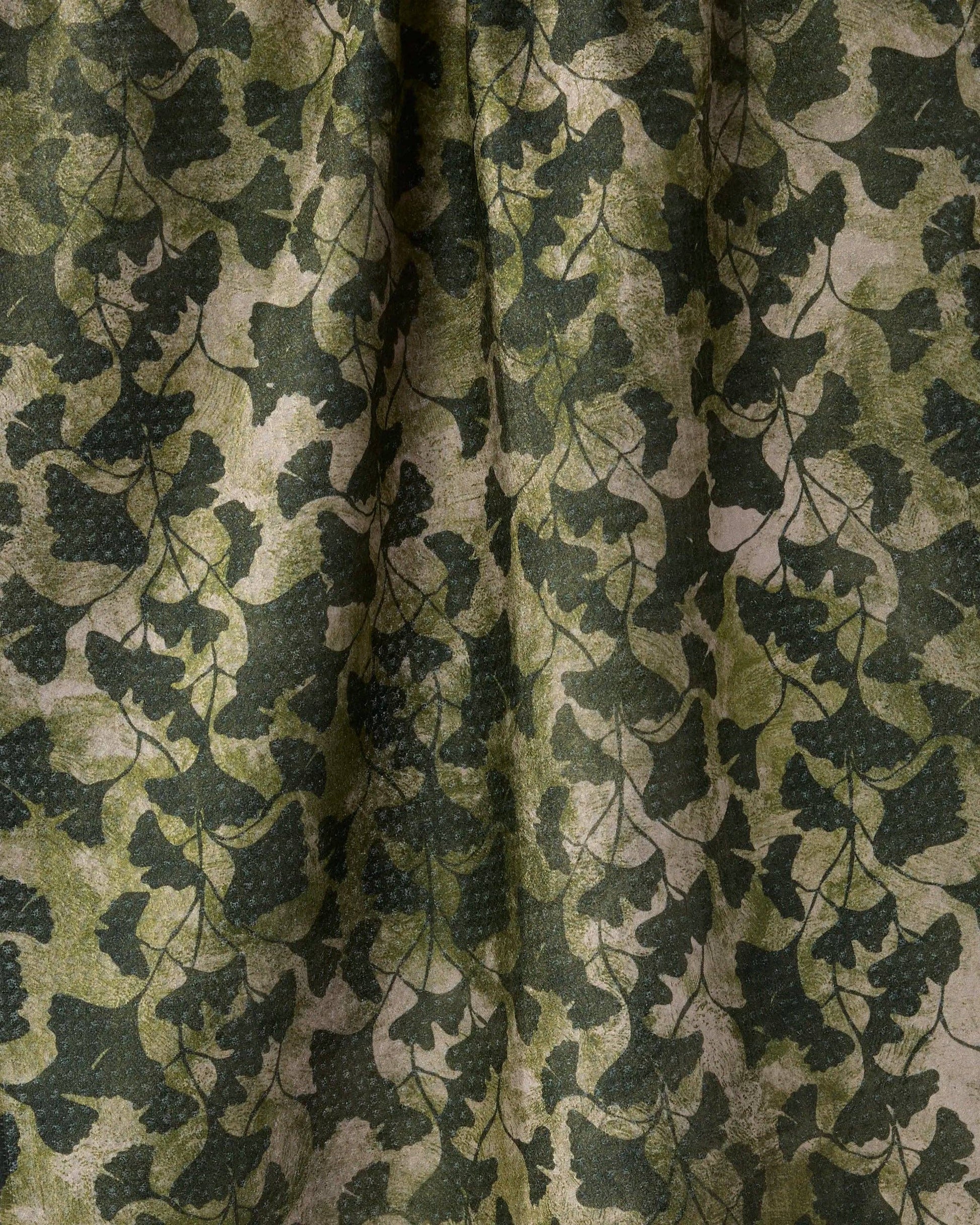 A close-up of a fabric or wallpaper pattern featuring a dark green grapevine and grape cluster design over a distressed beige background.