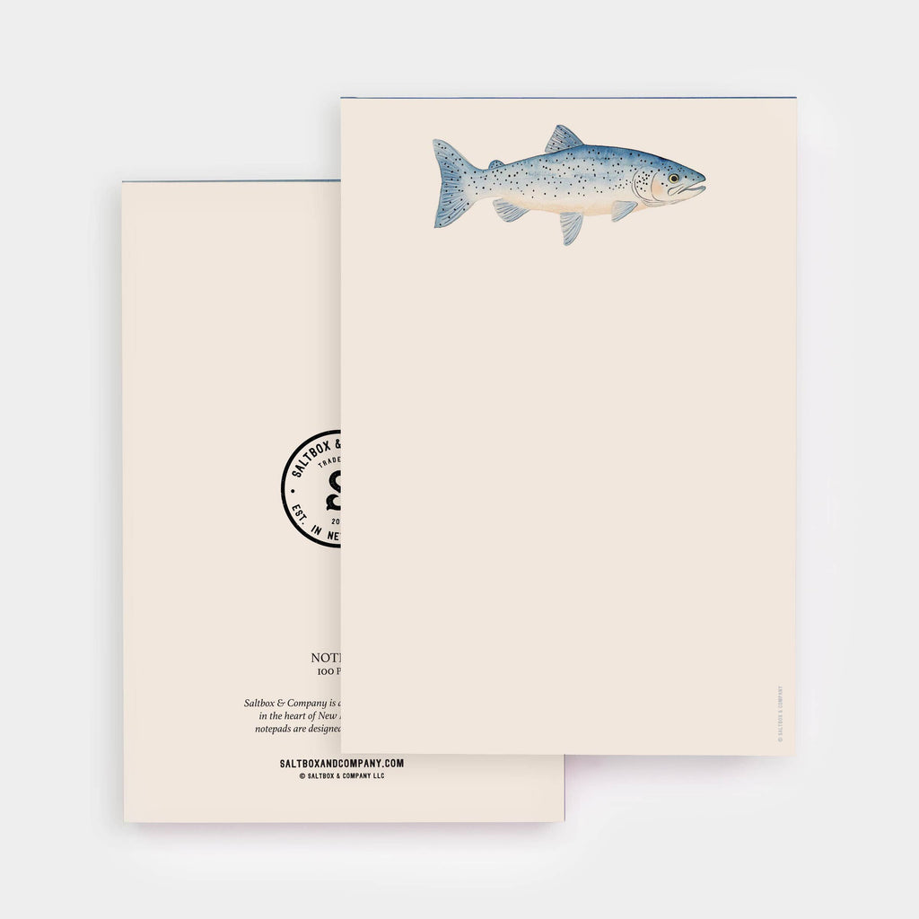 A minimalist stationery set featuring a cream-colored card with a detailed blue-gray trout illustration and a matching cream envelope with a black circular stamp design.