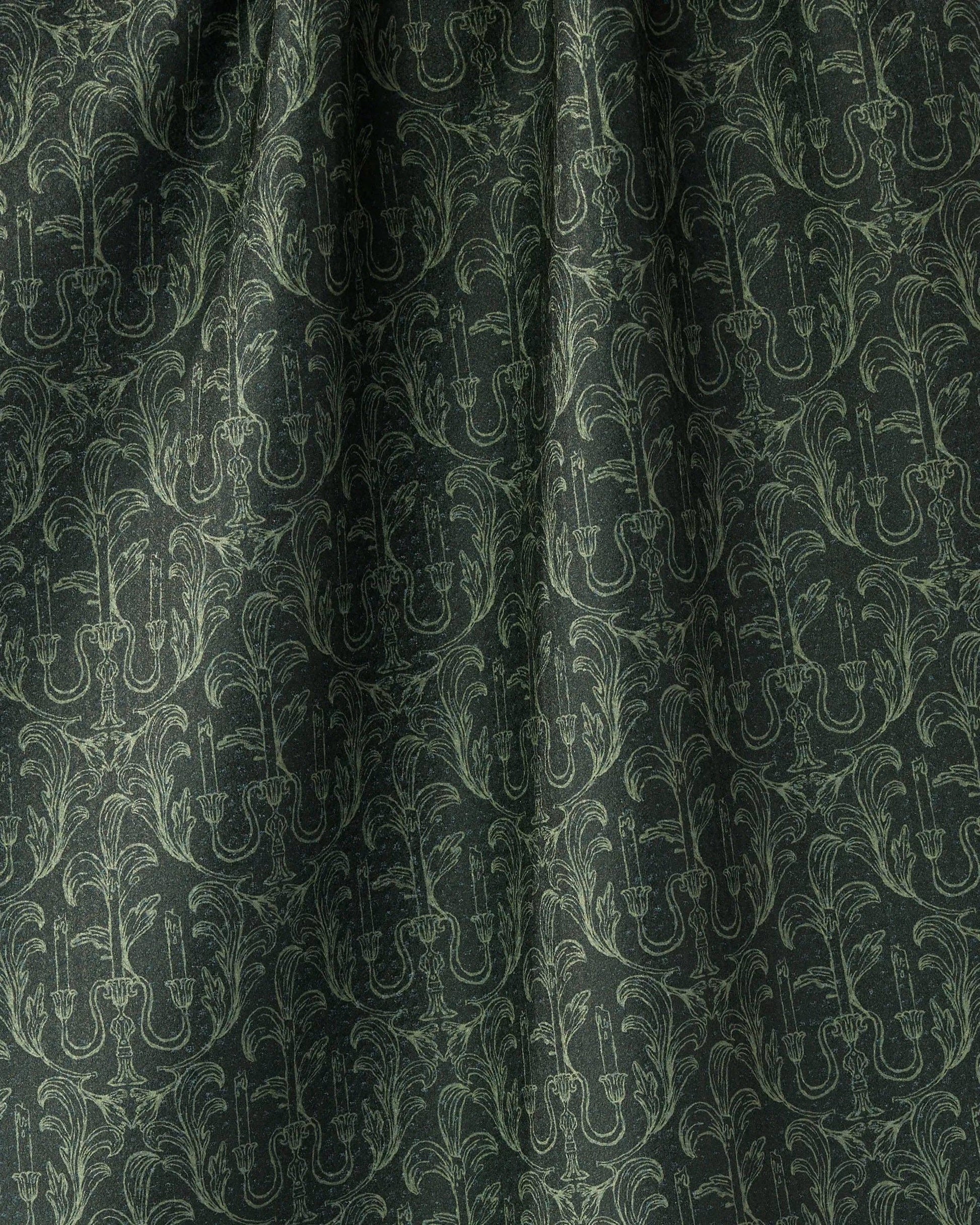 Dark green fabric with a repeating light sage green damask pattern of candelabras and ornate scrollwork.