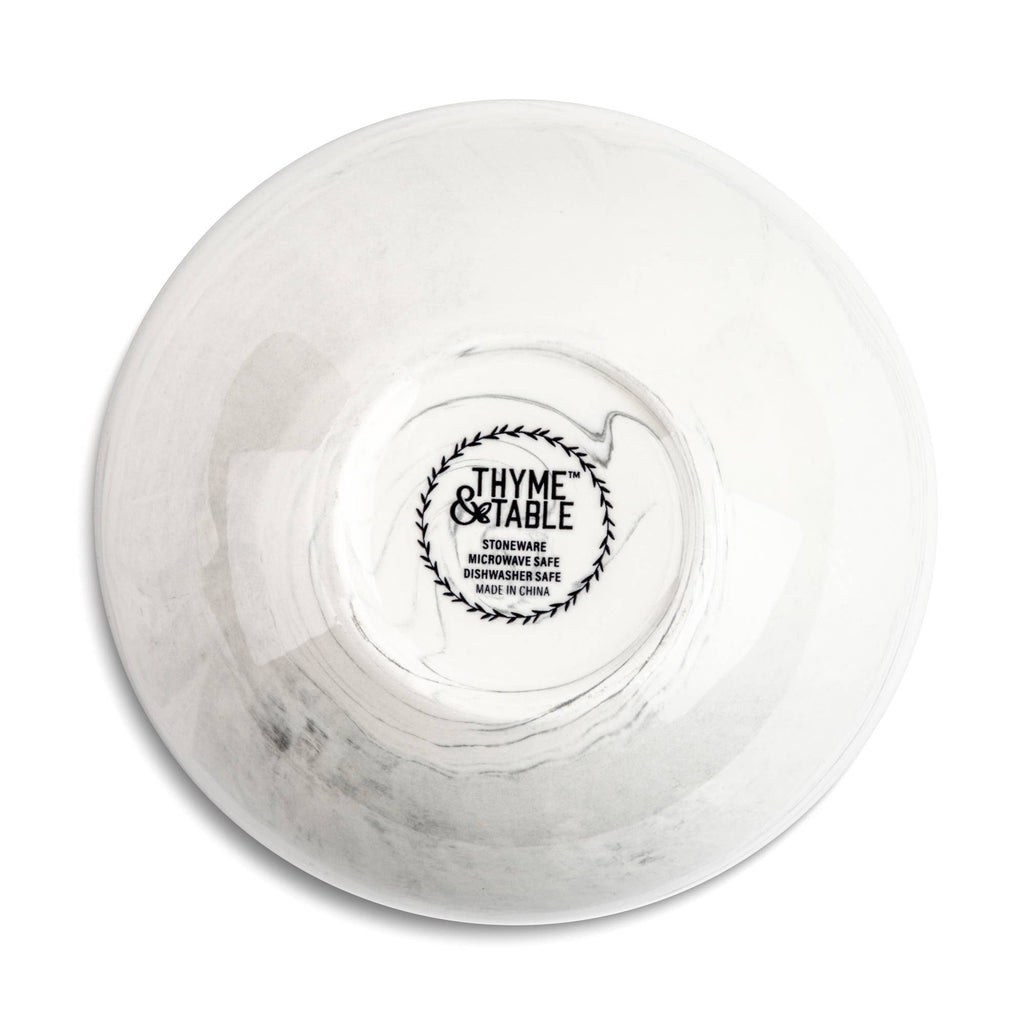 A white ceramic bowl with a subtle gray marbled pattern, shown from a top-down view on a white background. The inside of the bowl features a black printed logo for 'Thyme & Table'.