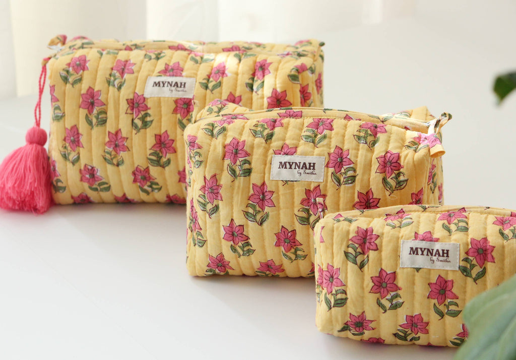 Set of yellow floral pouches with 'MYNAH' branding on a white background