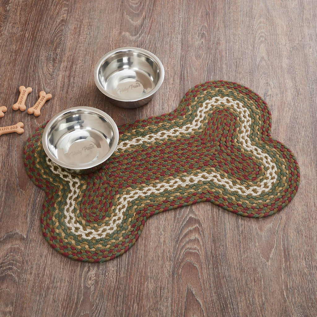 Dog bone-shaped mat with two metal bowls on a wooden floor