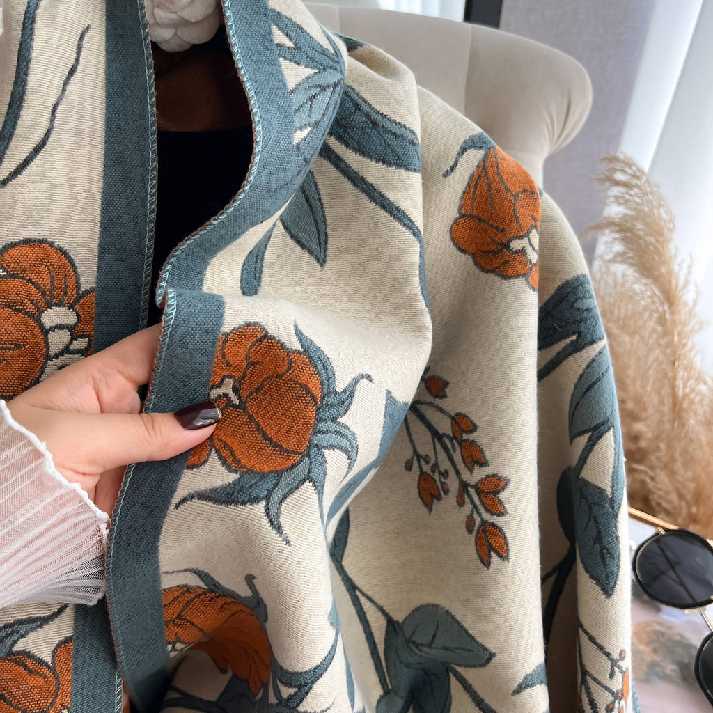 Close-up of a floral-patterned fabric with pumpkins and leaves.