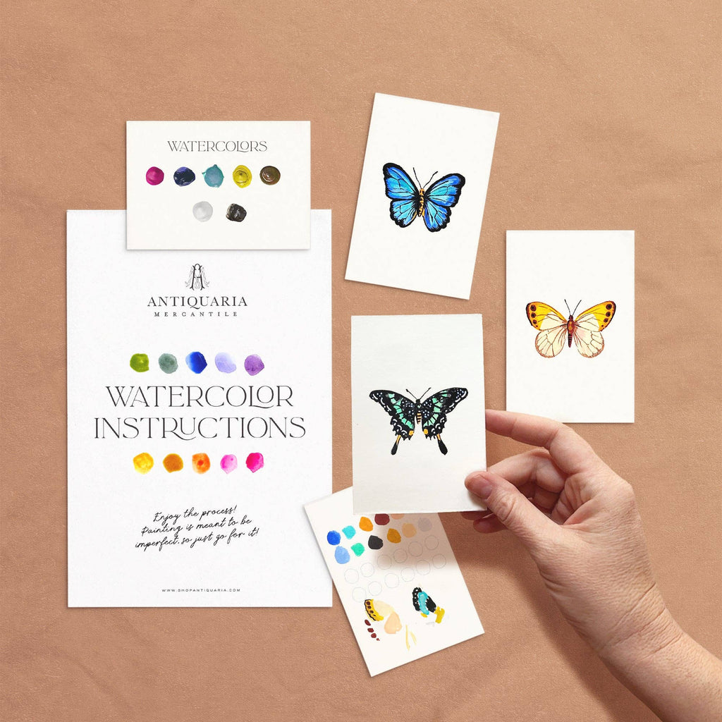 Butterfly watercolor cards with 'Antiquaria' branding on a brown background