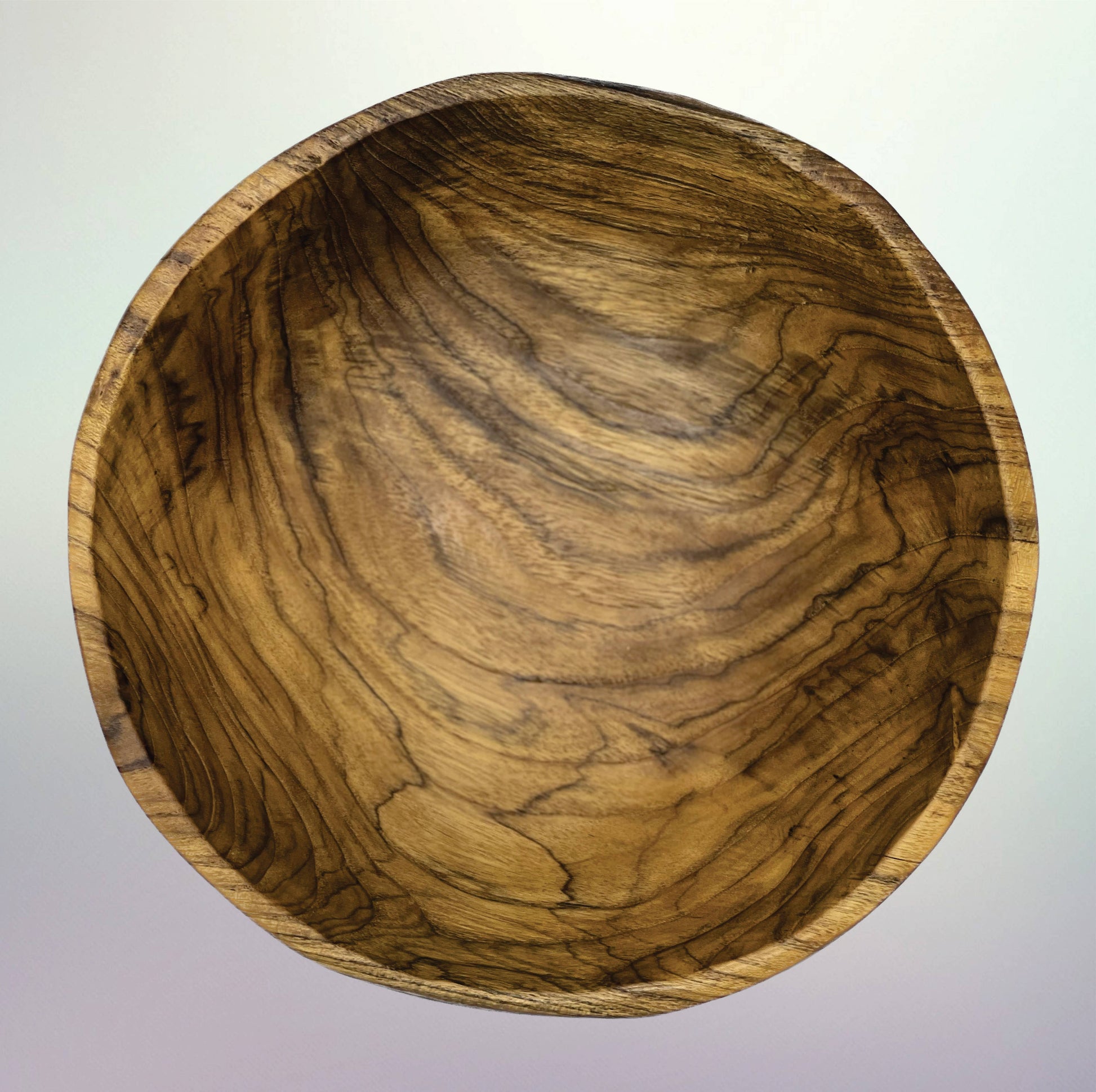 A round wooden bowl with a rich, swirling grain pattern in shades of brown and golden tan, photographed from directly above against a light gray gradient background.