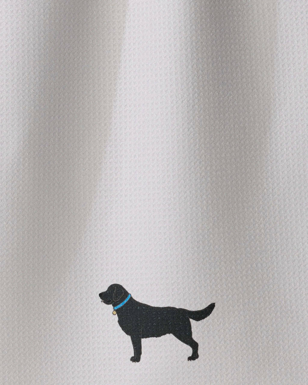 A close-up of a white textured fabric with a small black dog silhouette wearing a blue collar near the bottom center.