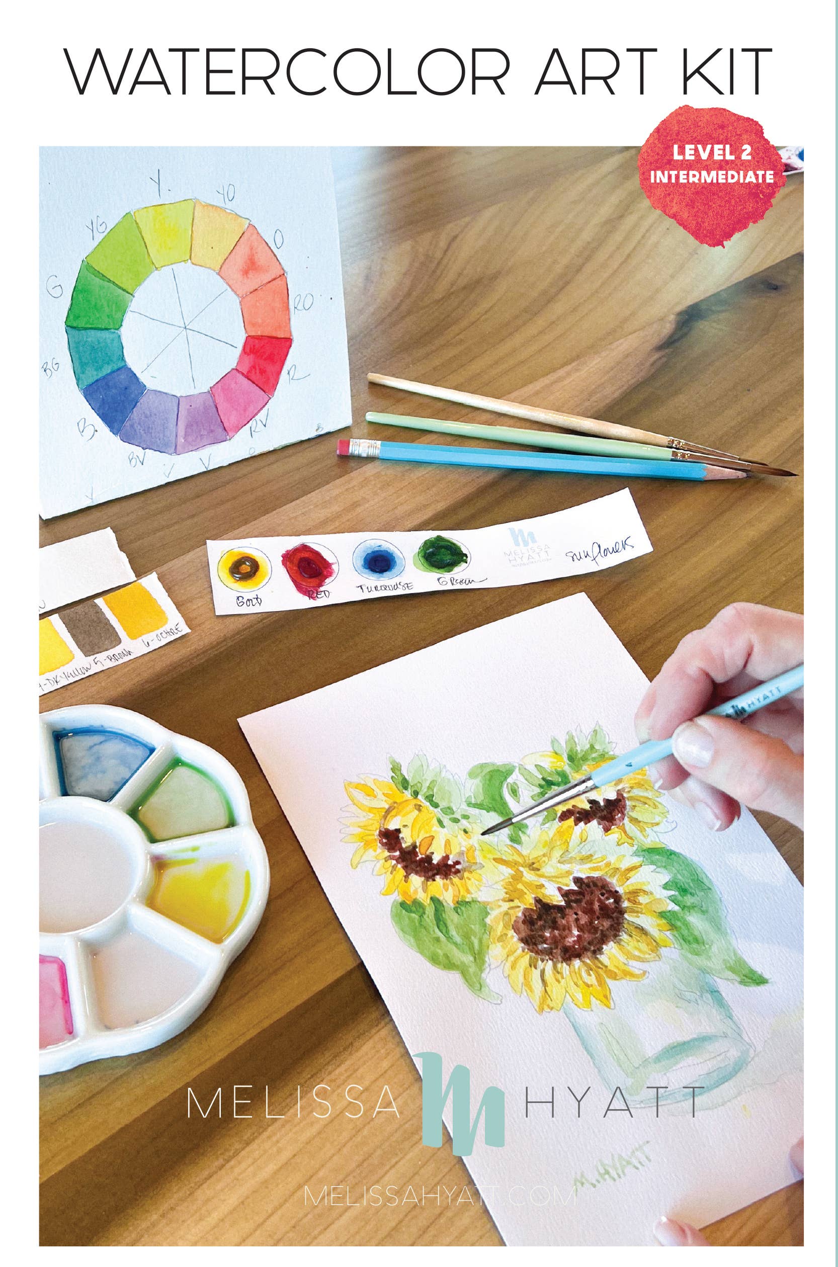 Watercolor art kit shown on a wooden table with a hand painting a sunflower, plus a color wheel, paint tubes, brushes, and a watercolor palette. Text at the top reads 'WATERCOLOR ART KIT' and 'LEVEL 2 INTERMEDIATE'.