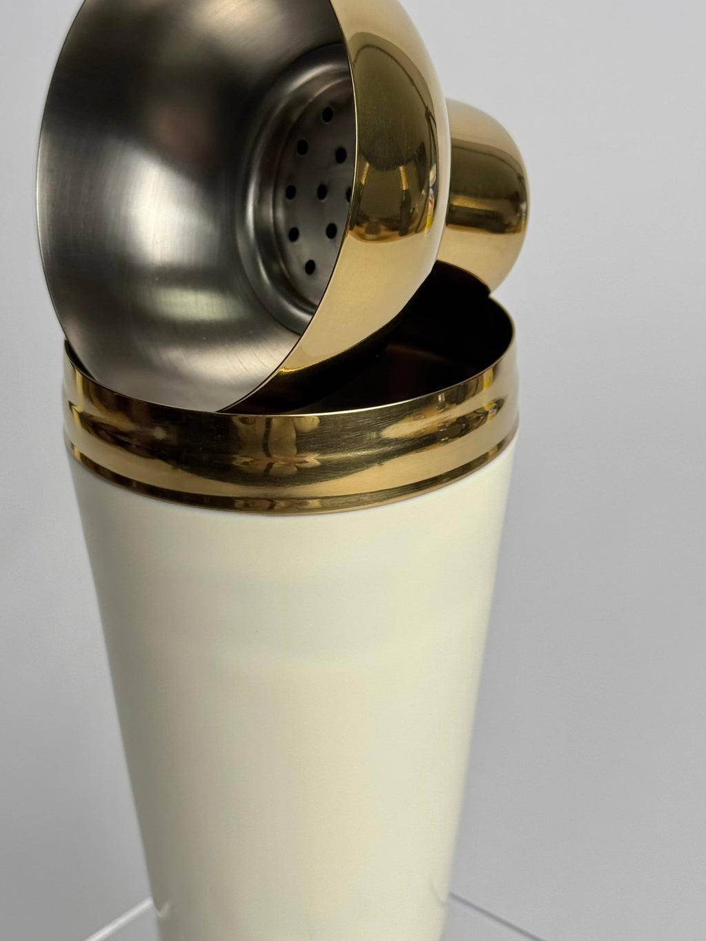 Shaker with gold and silver accents on a white background