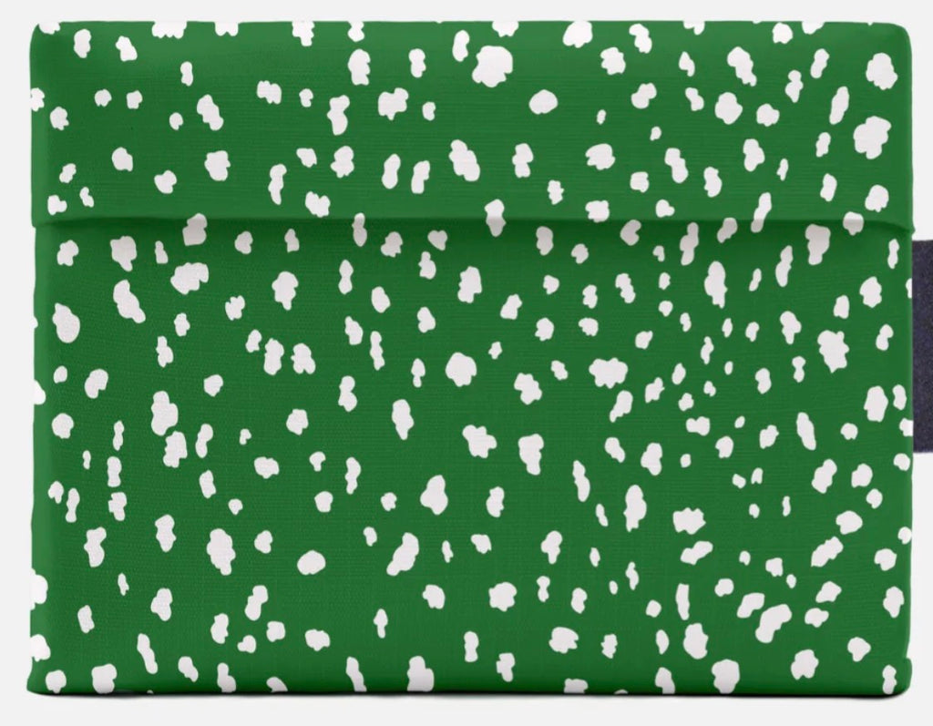 A green fabric pouch or sleeve with an all-over white irregular spotted pattern, shown flat against a light gray background.