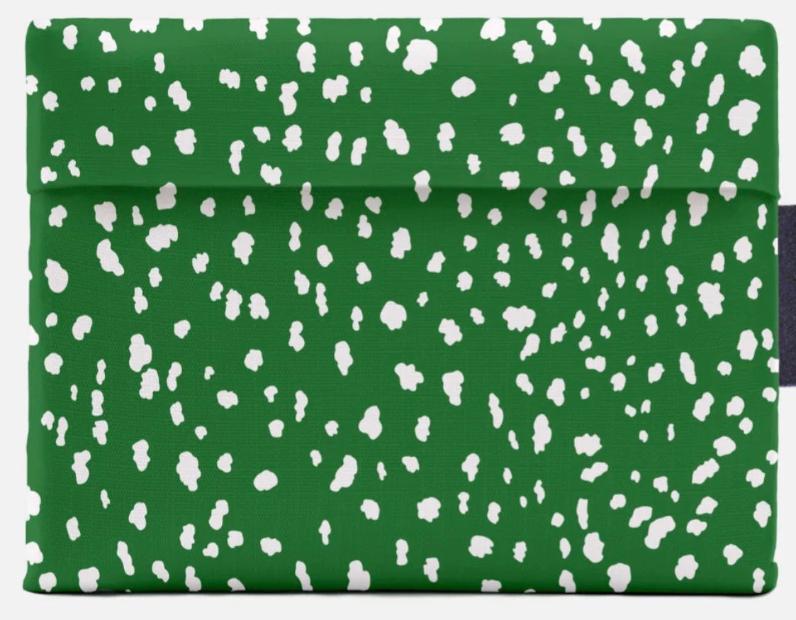 A green fabric pouch or sleeve with an all-over white irregular spotted pattern, shown flat against a light gray background.