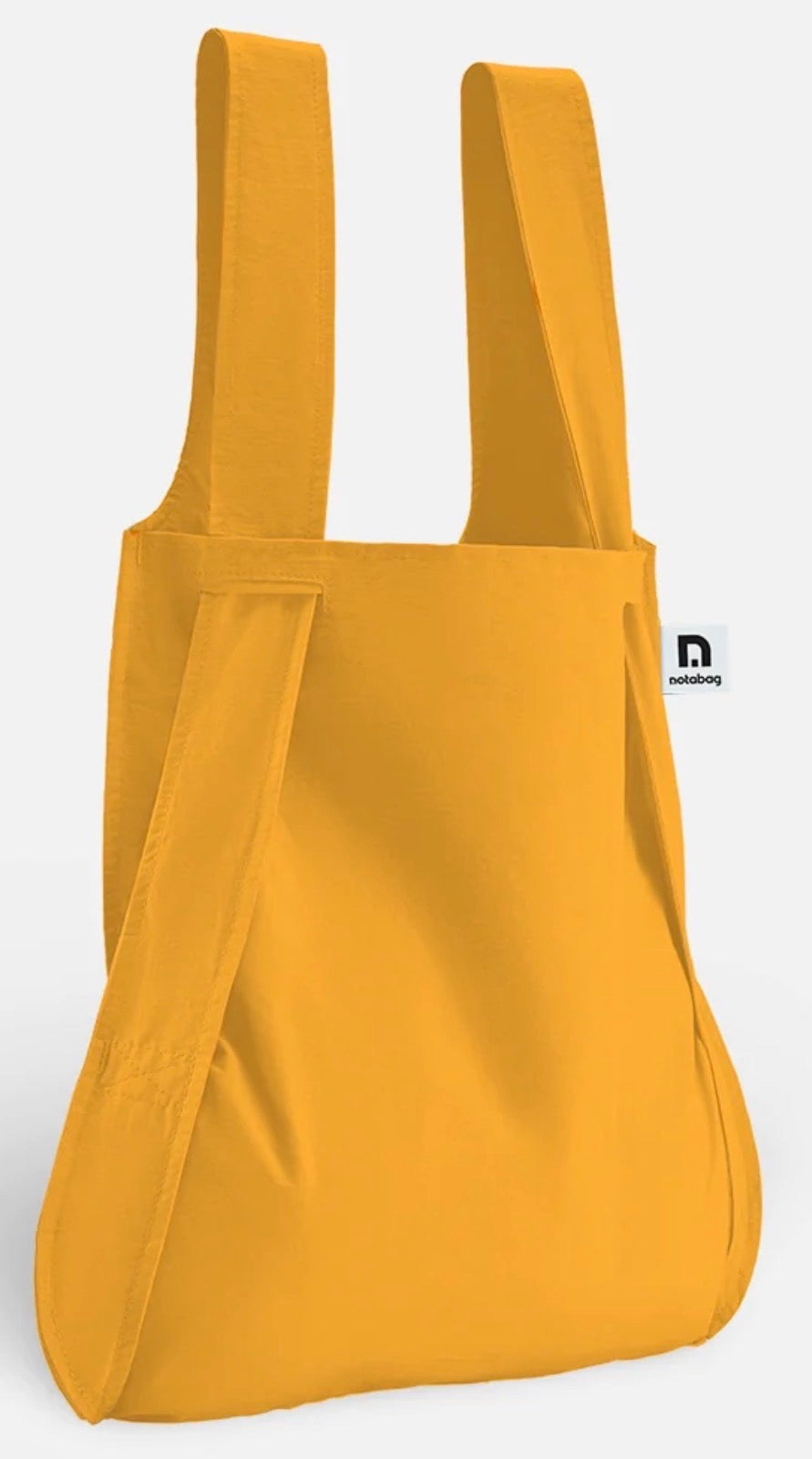A mustard yellow canvas tote bag with wide shoulder straps and a small white brand tag on the side, shown against a plain white background.