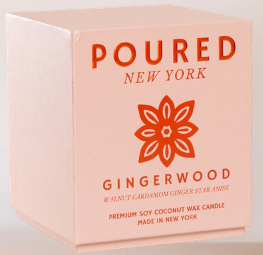A square pink box for a Poured New York Gingerwood candle, featuring orange-red text and a flower logo on a light gray background.