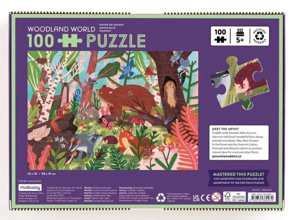 Front of a 100-piece jigsaw puzzle box titled 'Woodland World' by Mindful Mystery Puzzles. The box has a purple border and a colorful illustrated forest scene showing animals such as a bear, deer, bird, and squirrel in a woodland setting.