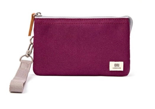 A small zip pouch in textured magenta fabric with a light beige wrist strap and a small white ORI LONDON brand patch on the front, set against a plain white background.