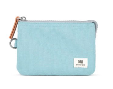 A light blue canvas zip pouch with a white ORI LONDON brand label on the front and a brown leather zipper pull, shown against a plain white background.