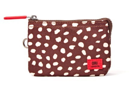 A small zippered pouch by ORI LONDON featuring a brown and white spotted pattern, with a red zipper pull and a red ORI LONDON brand patch on the front.
