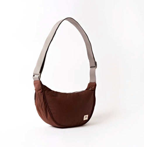A dark brown crescent-shaped shoulder bag with a light gray adjustable strap, shown on a clean white background.