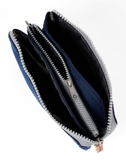 An open blue zippered wallet or pouch with silver-tone metal zippers and a dark navy interior, photographed on a plain white background.