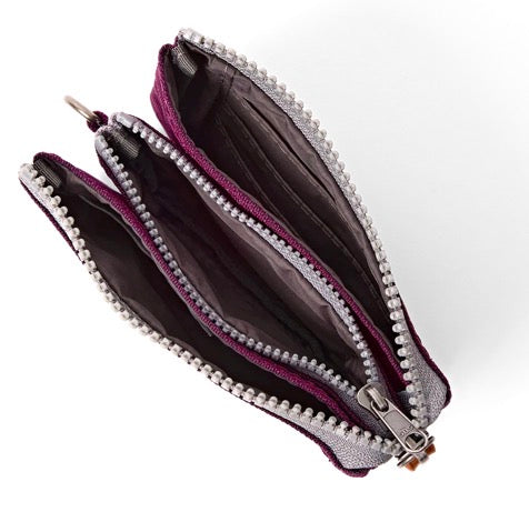 A small zippered pouch shown open on a white background, featuring a silver glitter exterior, a dark purple interior lining, and a decorative border of small white pearls along the zipper.