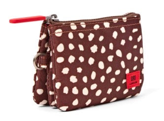 A brown canvas zippered pouch with a white spotted pattern, featuring a bright red zipper pull and a red brand patch on the front.