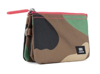 A small zip pouch with a camouflage pattern in brown, beige, green, and black, featuring a bright pink zipper pull and a black ORI London brand label.
