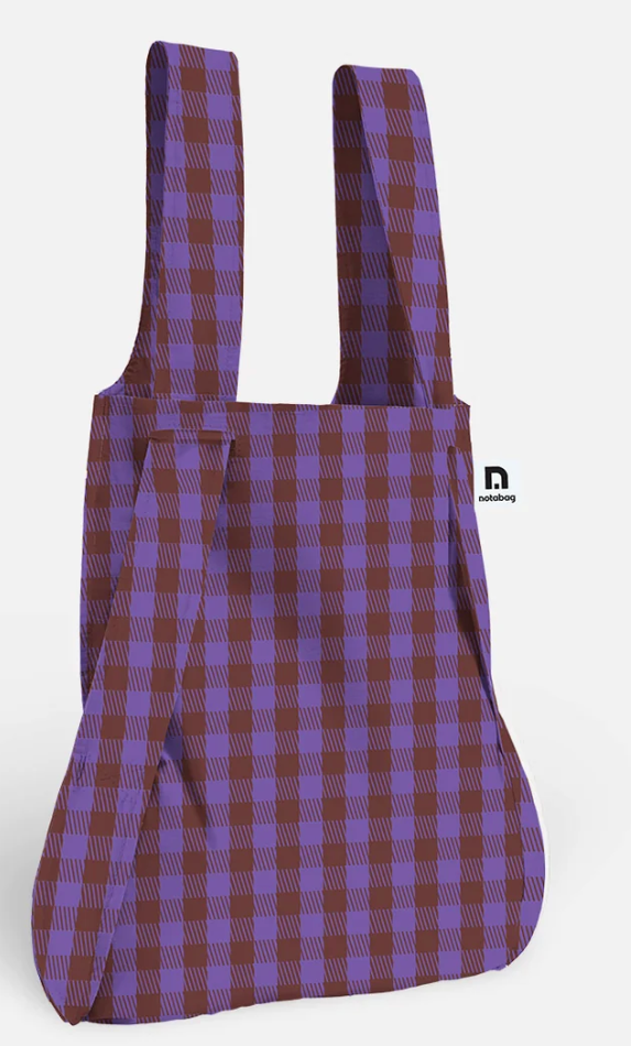 A reusable fabric tote bag with a purple and brown plaid pattern, featuring wide shoulder straps and a small black 'nordberg' logo on the right side, shown against a plain white background.