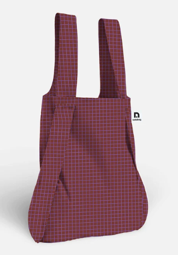 A burgundy tote bag with a thin purple grid pattern, featuring wide shoulder straps and a small black logo on the right side, set against a plain white background.