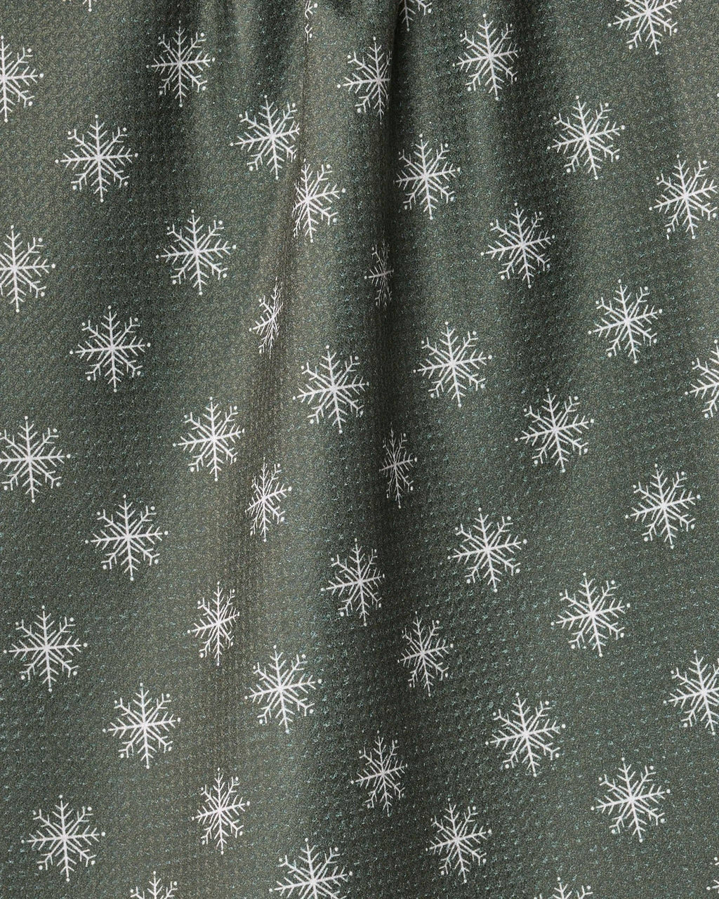 A close-up of a dark olive green textured fabric with a repeating white snowflake pattern.