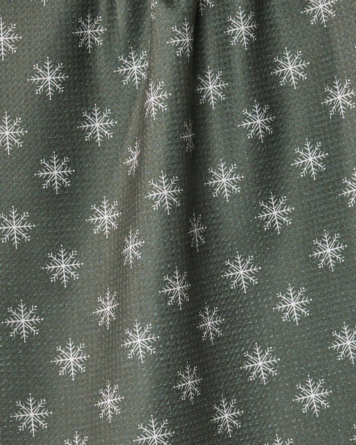A close-up of a dark olive green textured fabric with a repeating white snowflake pattern.