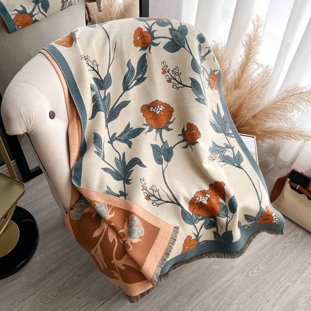 Floral patterned blanket draped over a chair with a neutral background