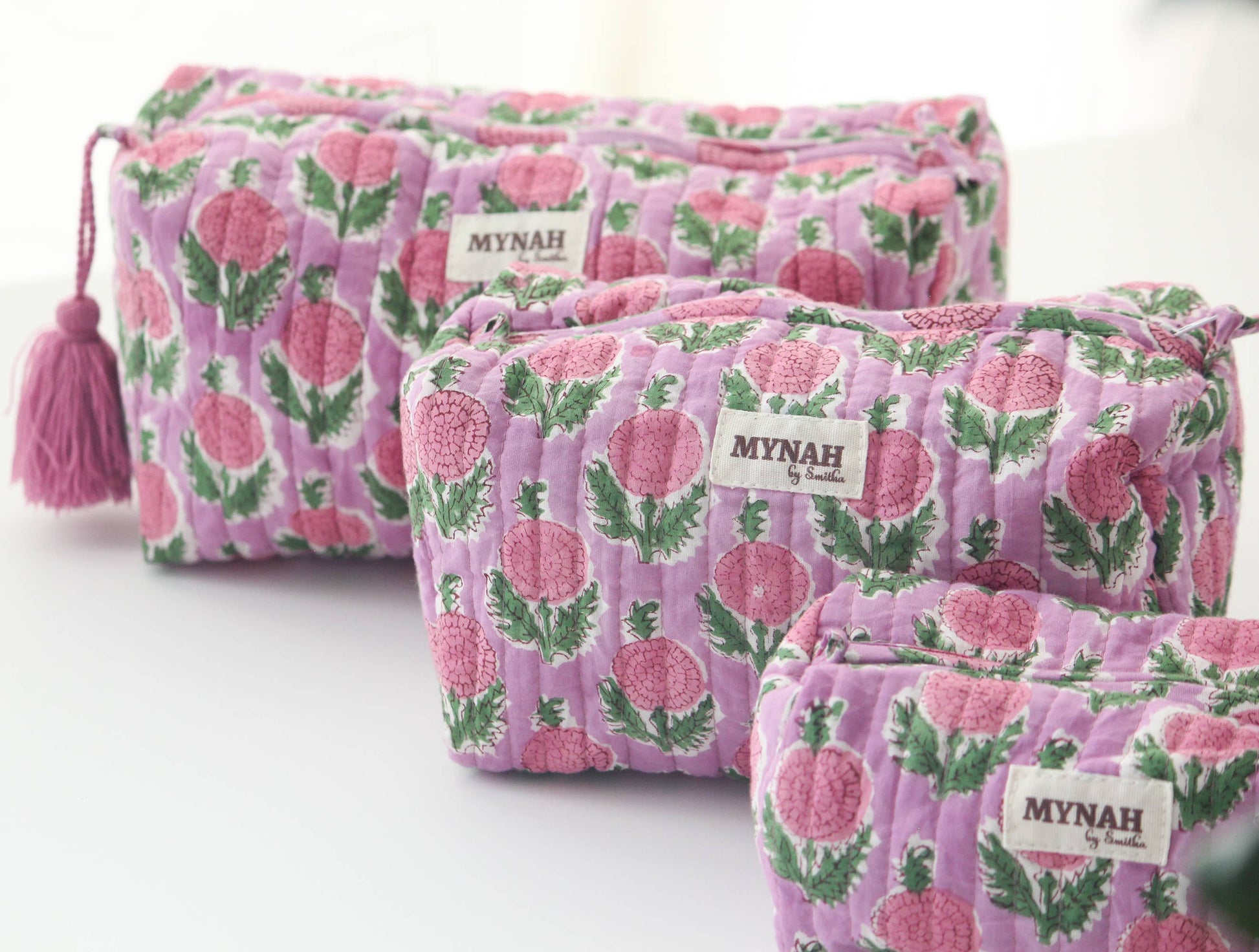 Set of three pink floral pouches with 'MYNAH' branding on a white background