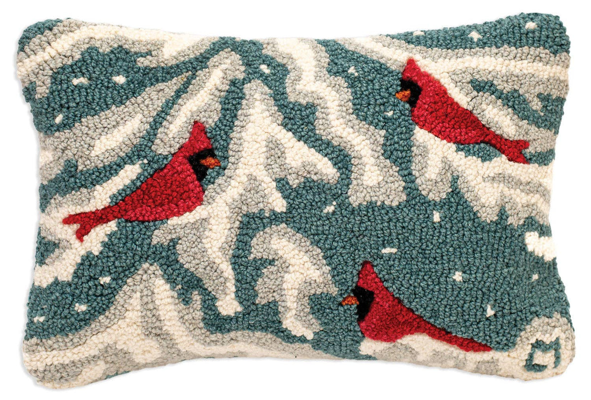 A rectangular hand-tufted wool pillow featuring a winter scene with red cardinal birds in front of snowy white and teal-blue mountain-like shapes.