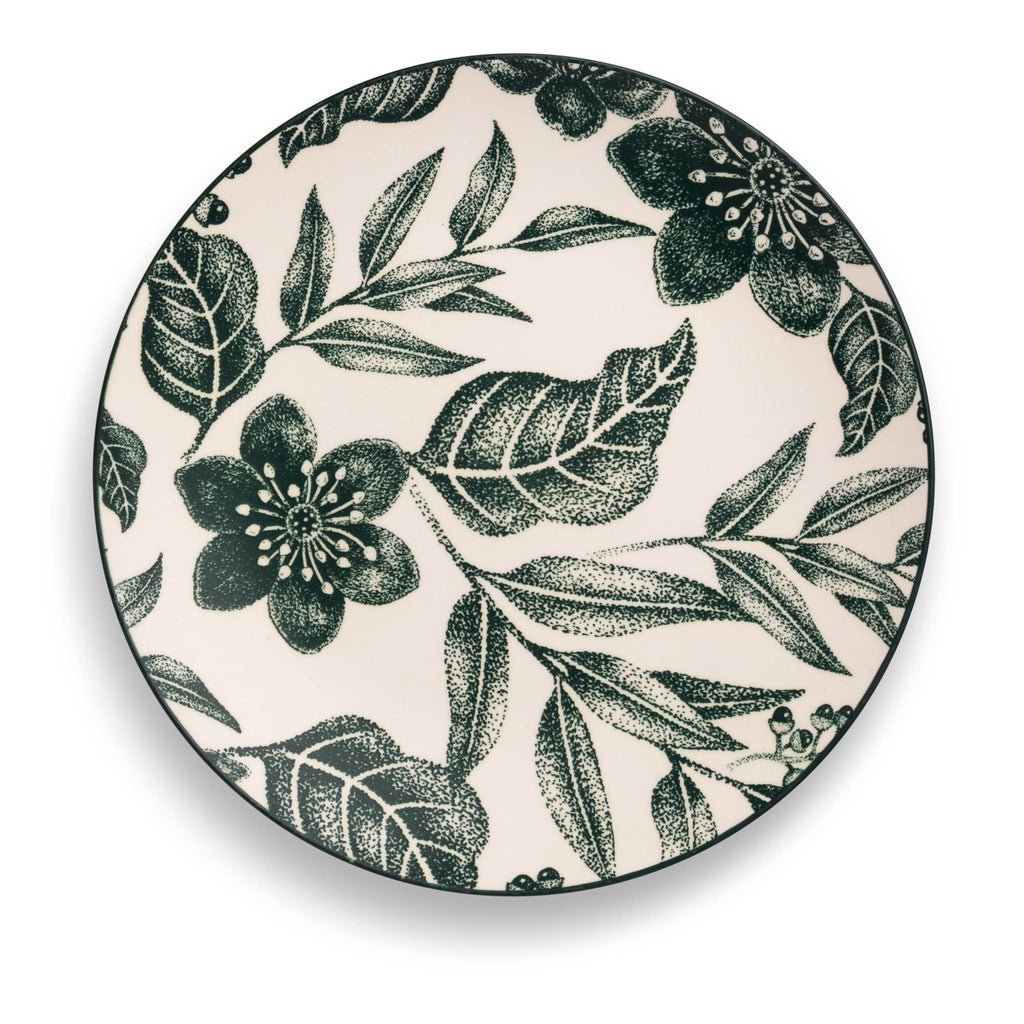 A round ceramic plate featuring a dark green botanical pattern of leaves and flowers on an off-white background, shown from a top-down perspective.