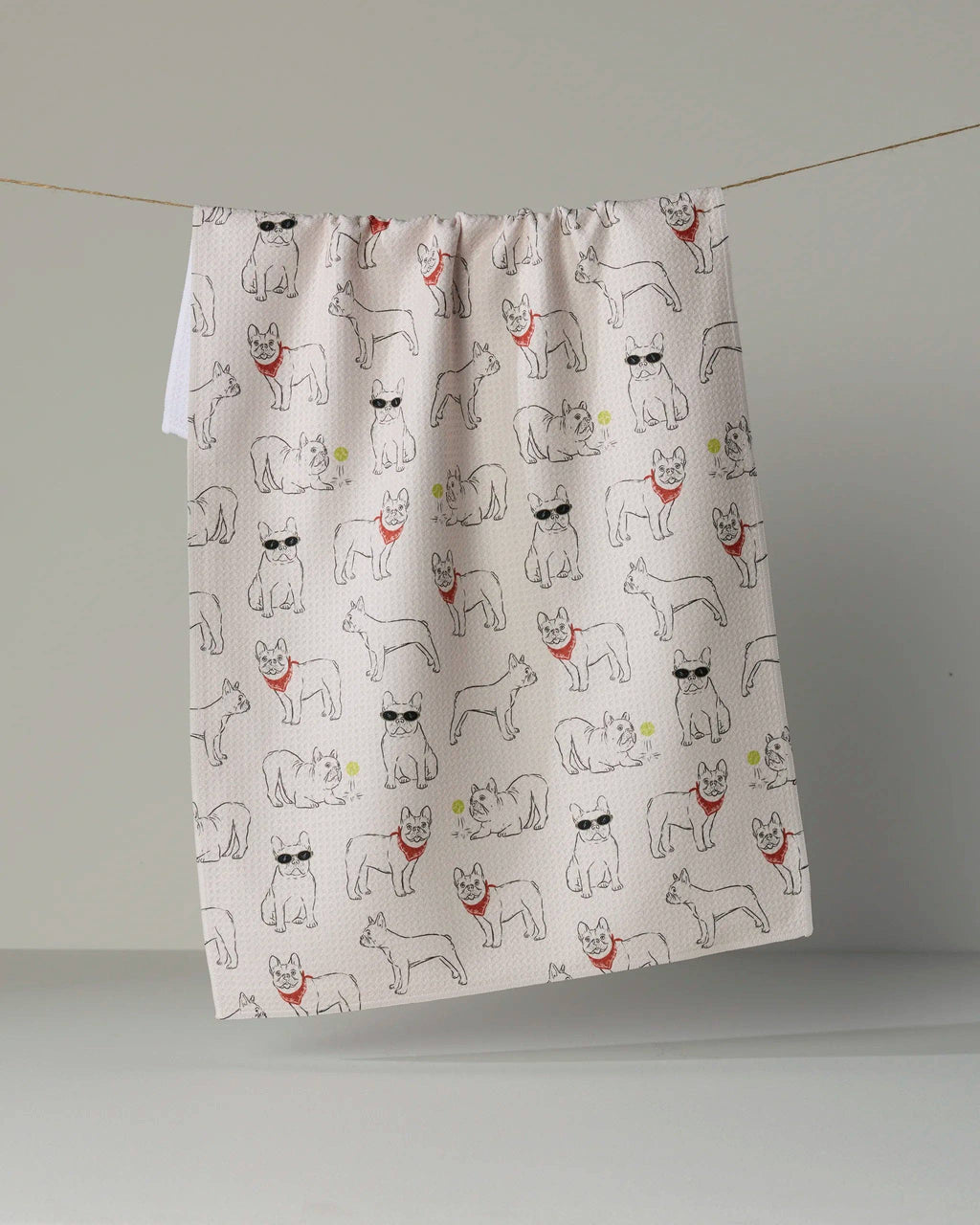 A fabric curtain panel with an all-over print of French Bulldog illustrations, hanging from a thin string against a neutral gray background.