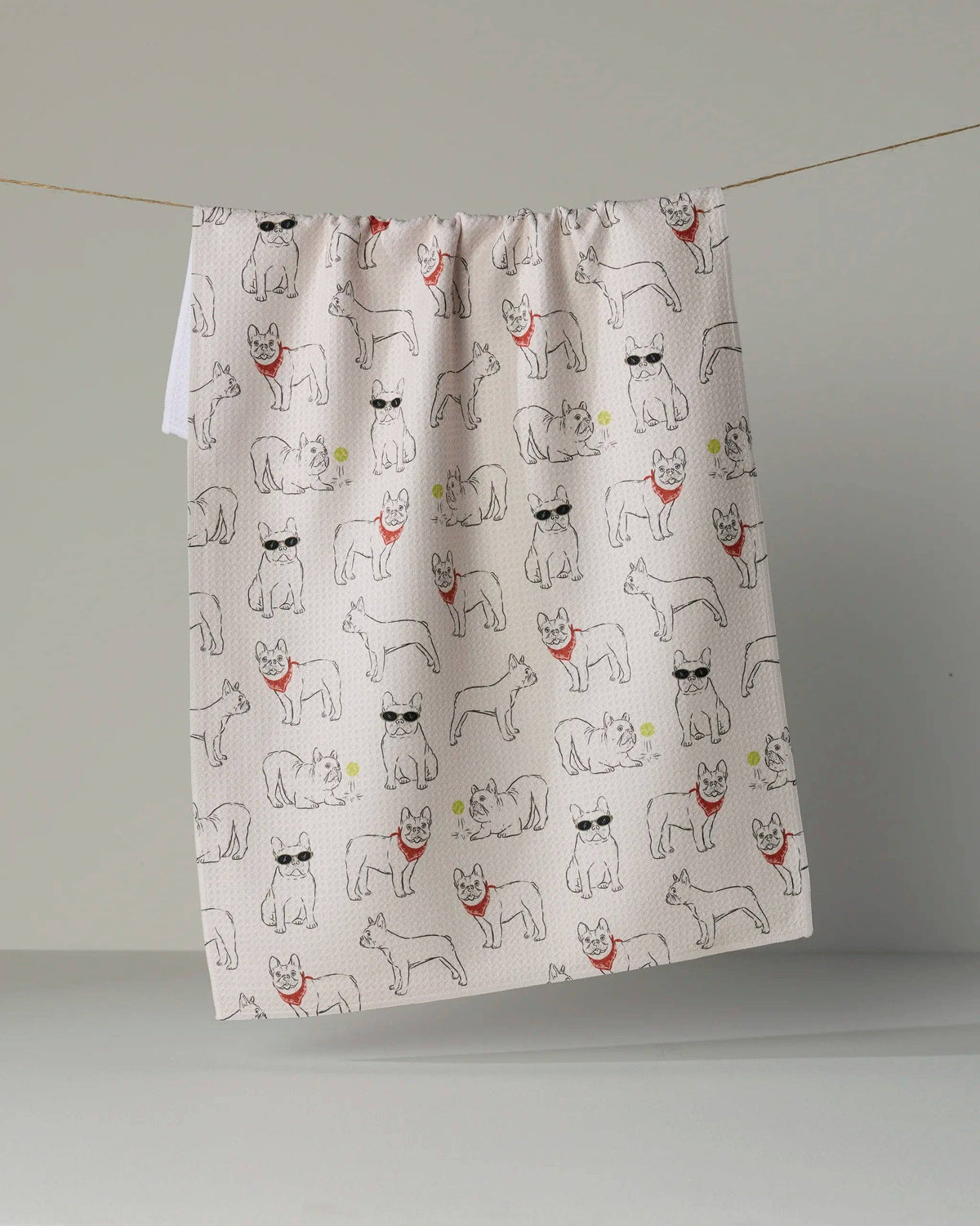 A fabric curtain panel with an all-over print of French Bulldog illustrations, hanging from a thin string against a neutral gray background.