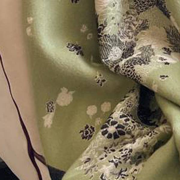 Close-up of a green fabric with floral patterns on a neutral background